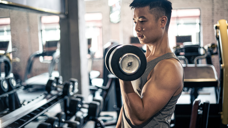 A man lifting free weights in a gym