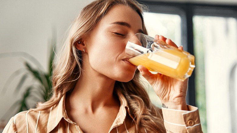 A woman drinking a glass of juice