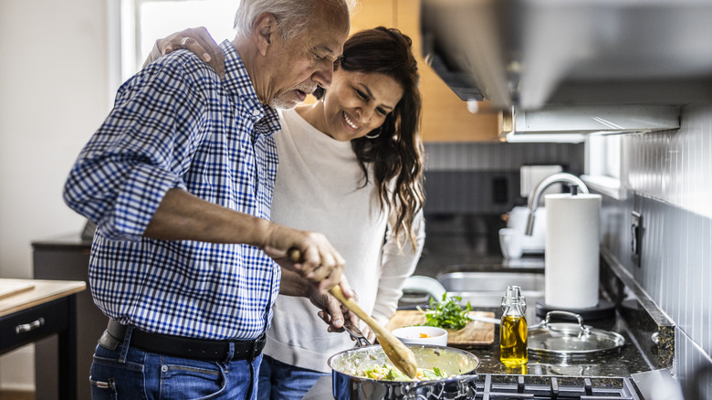 An older couple cooking in the kitchen