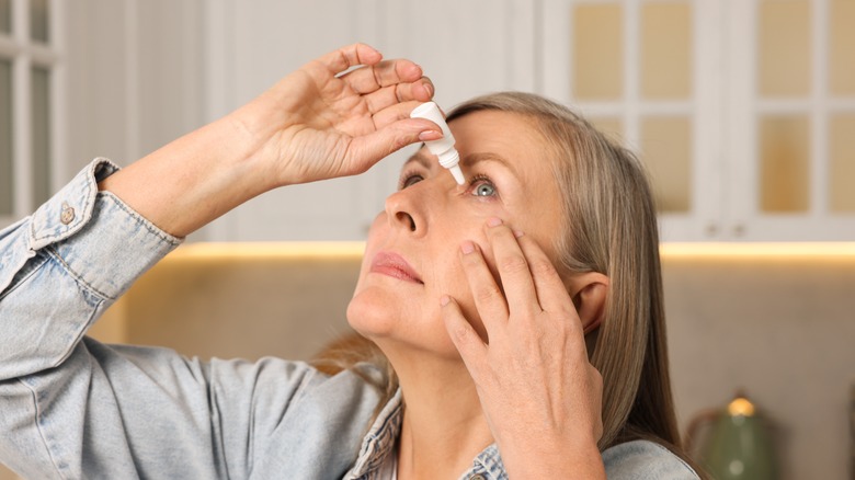 woman putting drops in her eyes