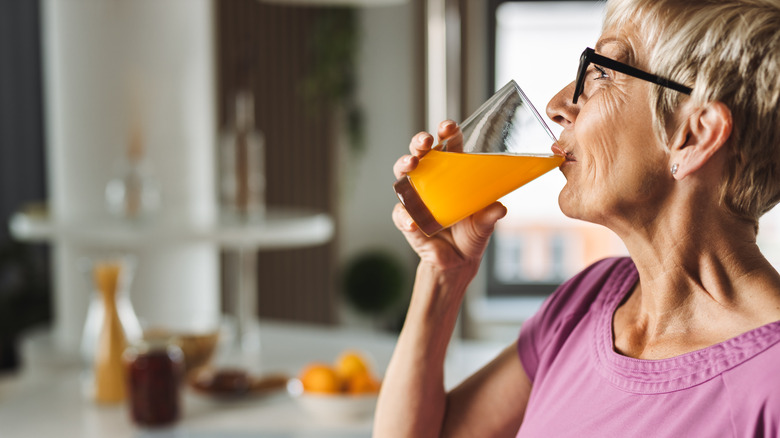 woman drinking juice in kitchen