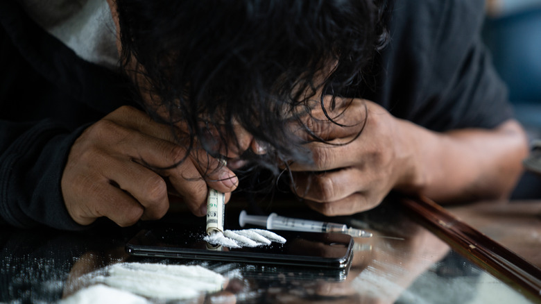 person snorting cocaine off a mirror