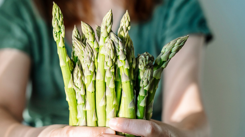 A woman holding asparagus spears