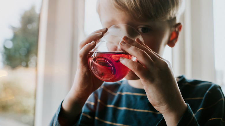 boy drinking a red beverage