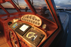 Modern electronics pair with old- school gauges on a helm’s mahogany console.