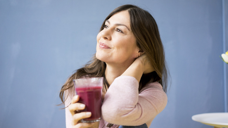 A woman drinking a purple juice