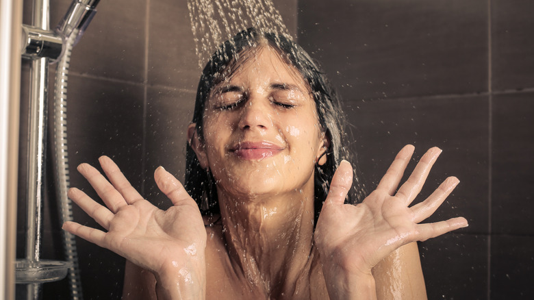 young woman under shower faucet