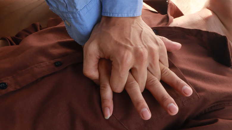 hands performing CPR on chest