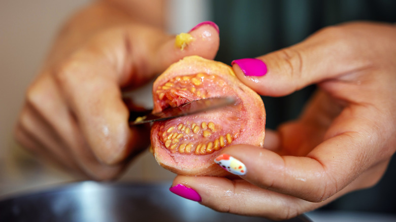 Woman cutting into guava