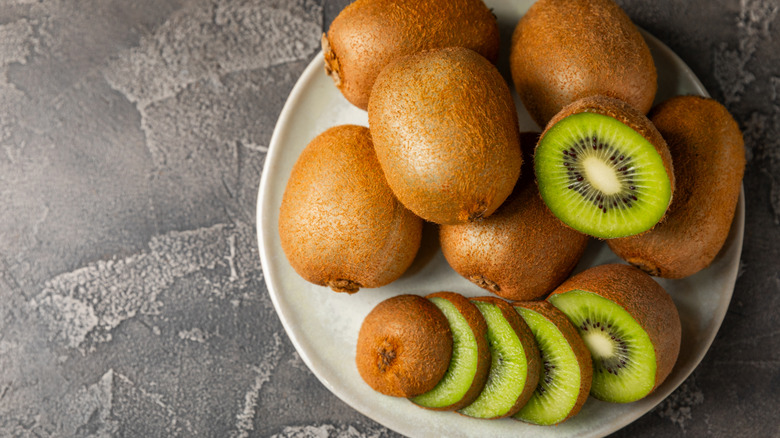 Plate of cut and whole kiwi