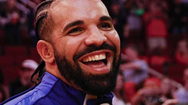 photo of rapper Drake smiling while at pro sport event