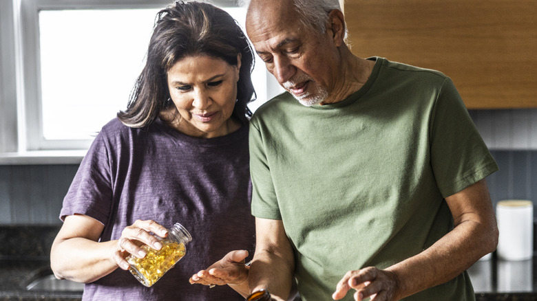 older couple taking vitamins and supplements