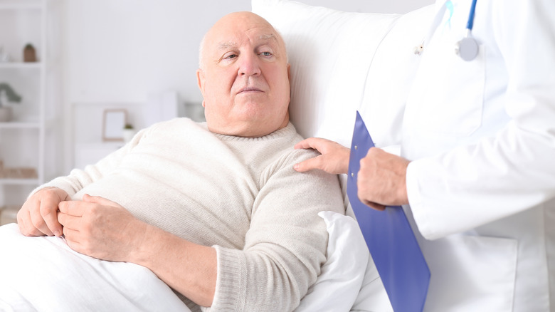 Doctor placing a hand on his terminal cancer patient's shoulder