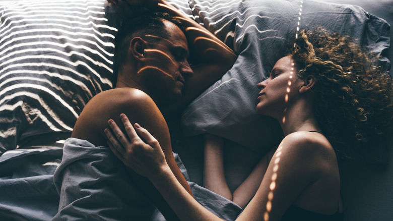 two people sleep in bed together