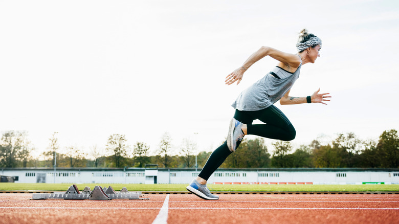 A woman sprinting on a red running track